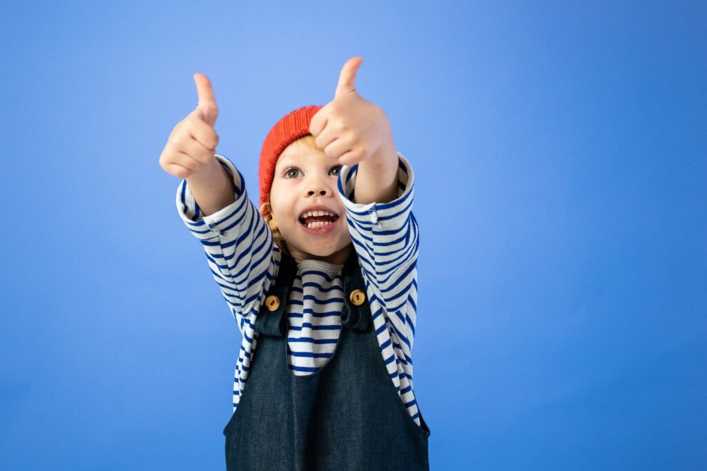 A child is shown with two thumbs up, similar to the "thumbs-up" system used to self-monitor and self-evaluate for articulation students in speech therapy. This is a good tip for supporting self-monitoring skills in articulation students.