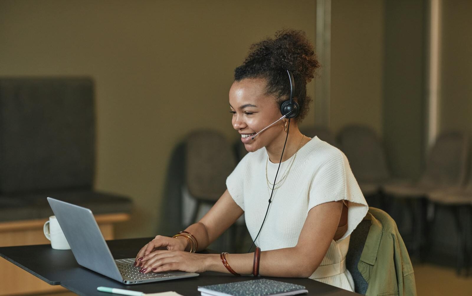 A Woman with Curly Hair Working while Smiling