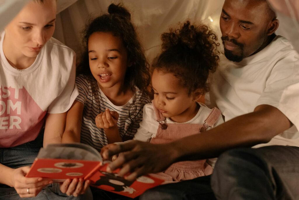 Parents Reading a Book to Their Children. Modeling while reading is a good way for parents to support articulation carryover at home.